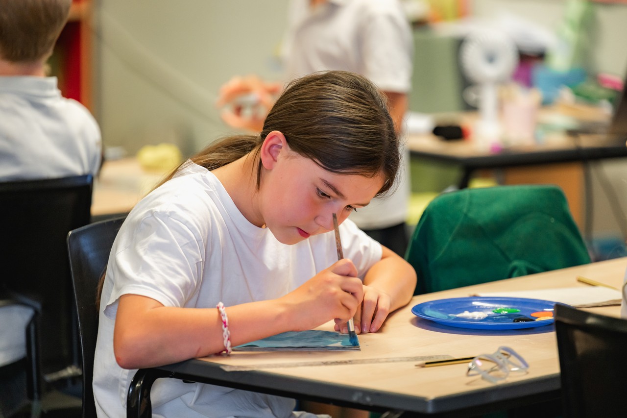 A child seated, engaged in painting A child seated, engaged in painting