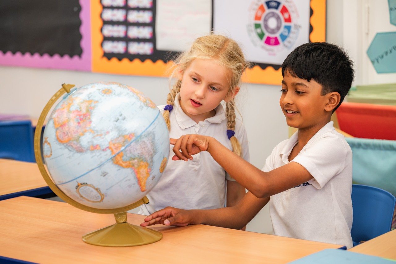 Children resting notebooks on a nature reserve lectern board